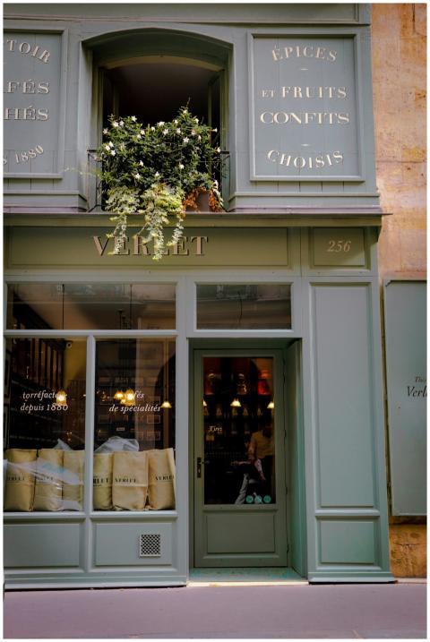 Charming green storefront in Paris with plants and