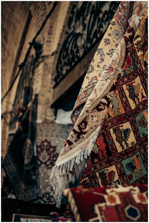 Vibrant Persian rugs displayed in a Shiraz market,