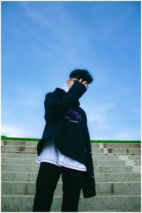 Fashionable young man poses on outdoor stairs on a