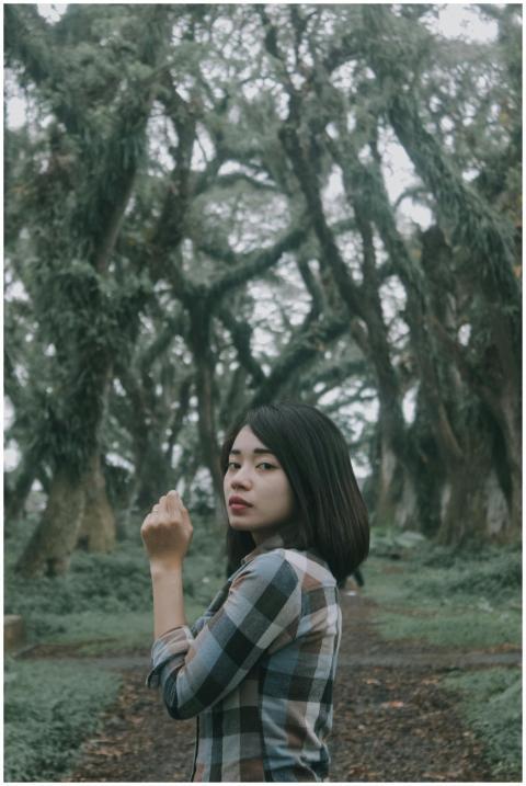 Young woman with short hair poses in a dense Banyu