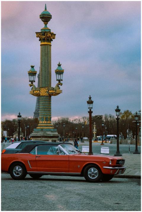 Vintage red car parked near iconic Place de la Con