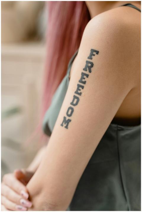 Vertical shot of an arm tattooed with the word 'Fr