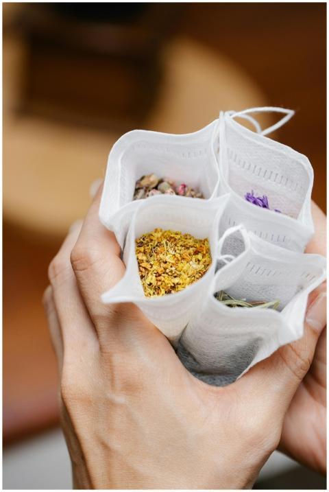 Close-up of hands holding various herbal tea bags