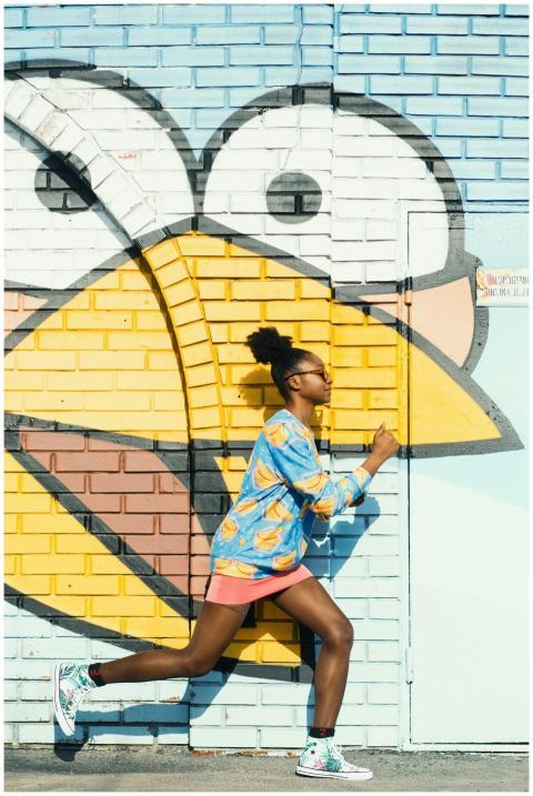 Dynamic scene of a woman running against a colorfu