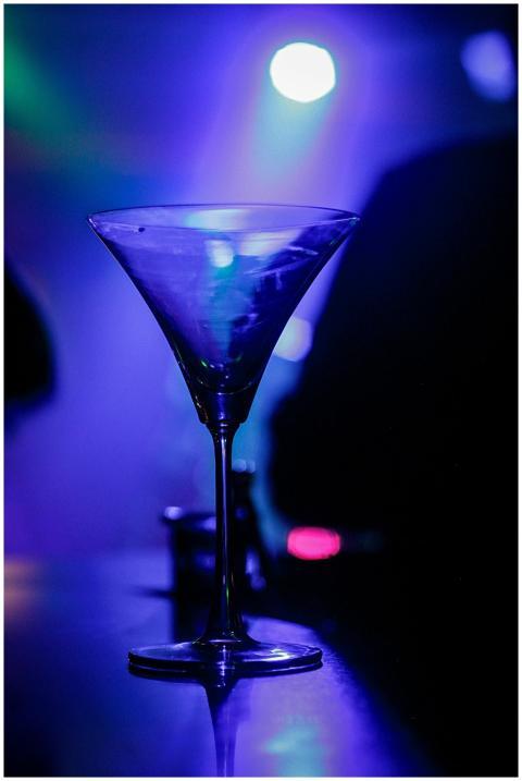 A crystal martini glass glows under vibrant nightc