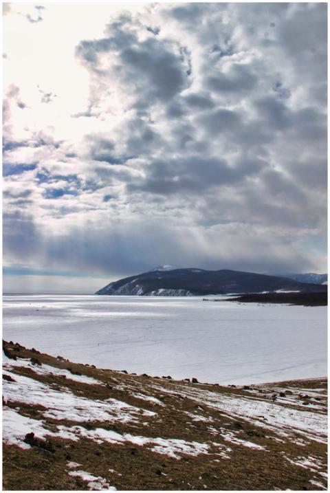 A breathtaking view of a frozen lake with snow-cov