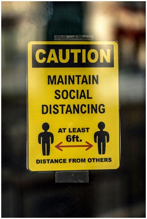 A caution sign promoting social distancing measure