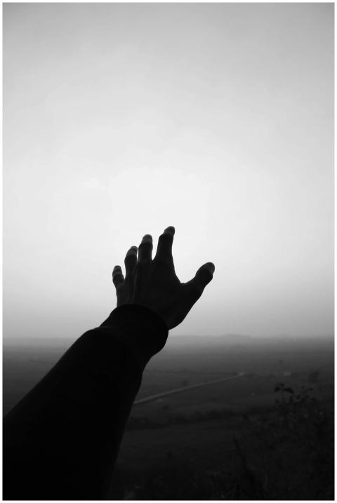 Monochromatic image of a hand reaching towards the