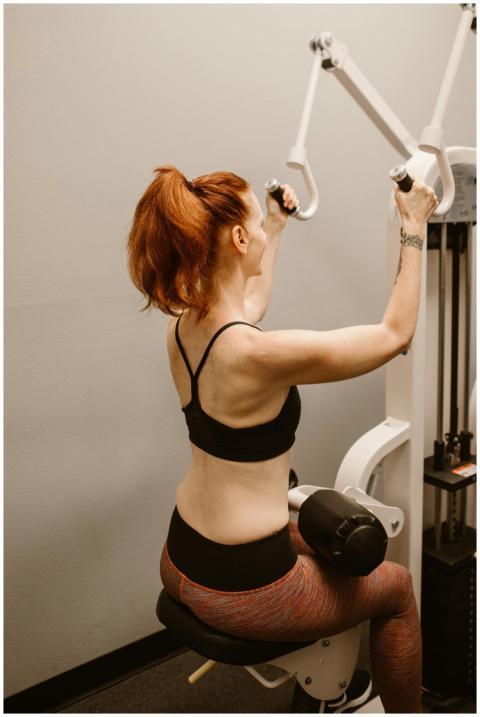 Fit woman exercising on gym equipment focusing on