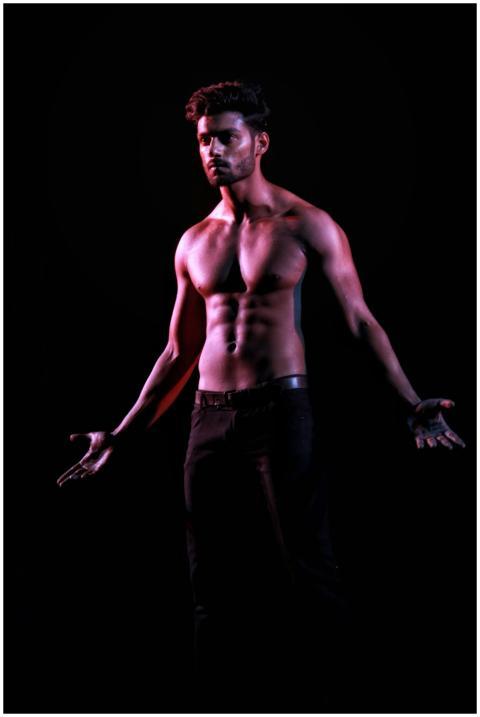 A shirtless male model posing with dramatic lighti