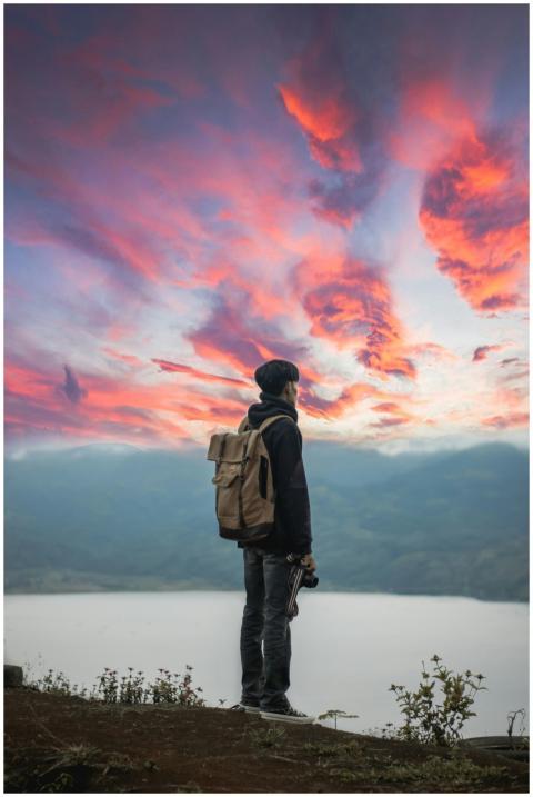 A lone backpacker stands on a mountain top in Indo
