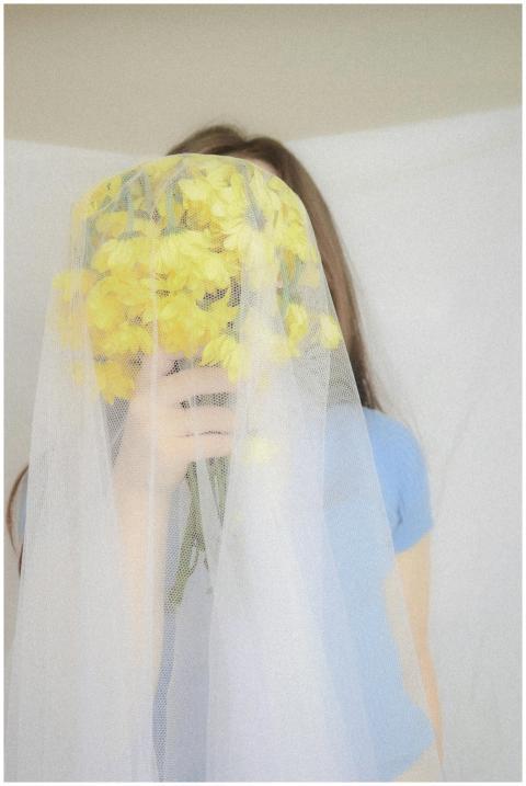 Artistic portrait of a young woman with yellow flo