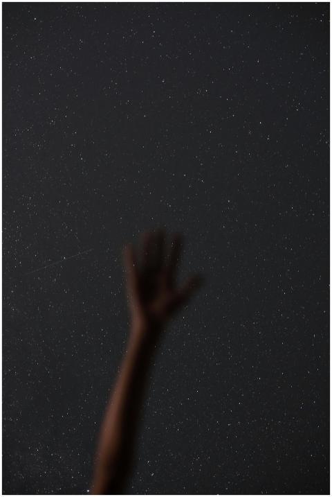 Silhouette of an extended hand reaching towards a