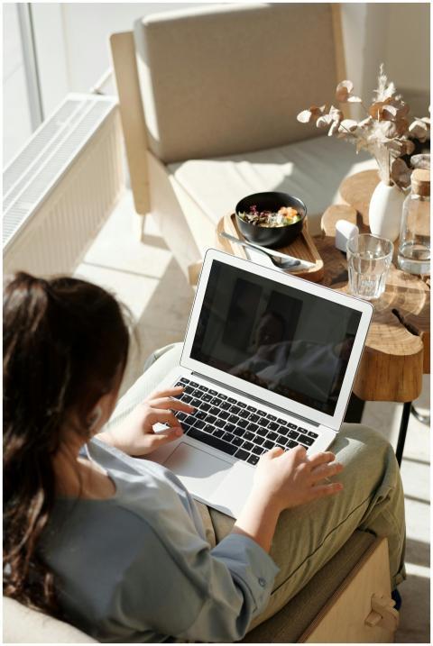 Woman enjoying remote work on a laptop in a cozy h