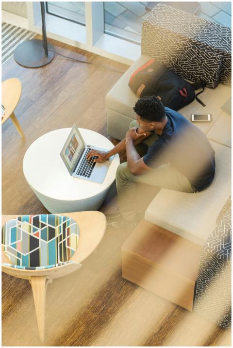 Young man working remotely on laptop in a stylish