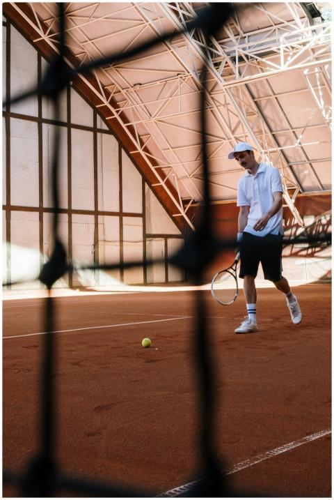 Adult male tennis player on an indoor clay court p