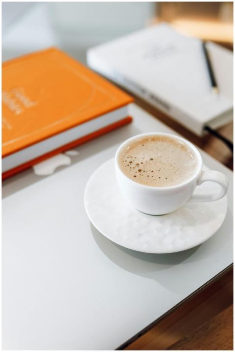 A cozy desk setup with a cup of coffee, a laptop,