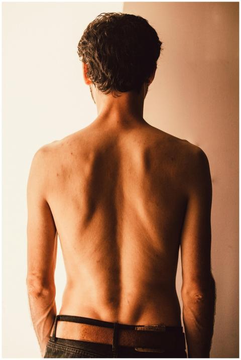 Artistic image of a shirtless man from behind, sho
