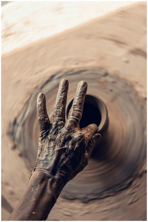 Artist shaping clay on a pottery wheel, showcasing