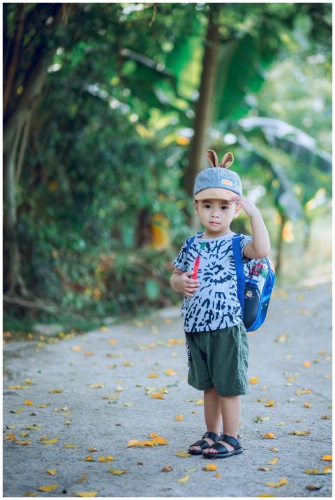 Adorable young boy with backpack enjoying a summer