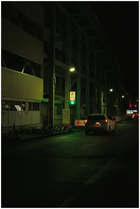 A car drives through a dimly lit urban street at n