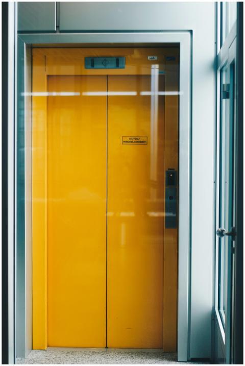 A bold yellow elevator door captured indoors, offe