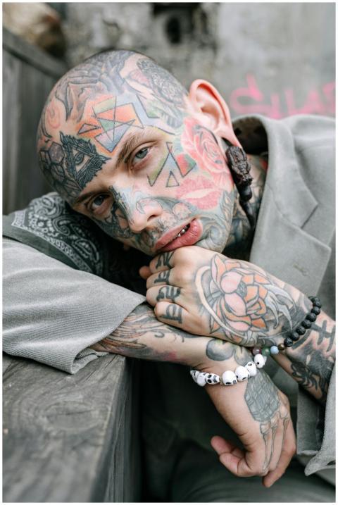 Close-up portrait of a tattooed man in a contempla