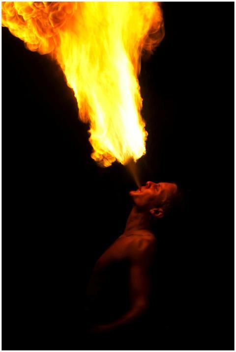 A performer showcasing a dramatic fire breathing s