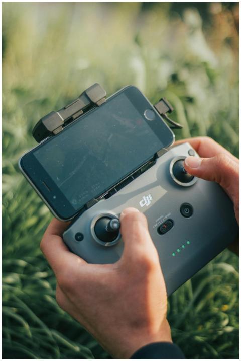 Close-up of hands holding a drone controller attac