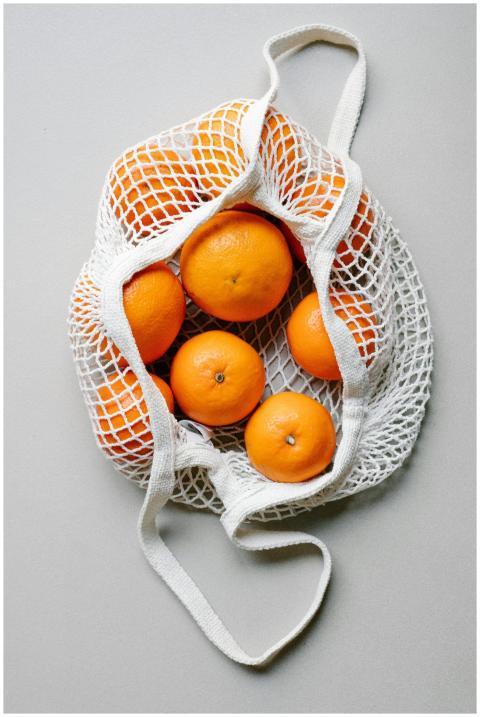 Top view of fresh oranges placed in white eco frie
