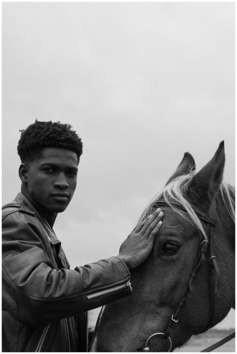 Black and white portrait of a young man gently tou