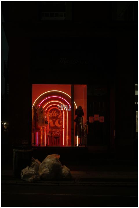 Dimly lit city storefront with vibrant neon lights