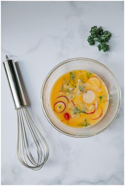 Top view of whipped egg yolk with herbs and veggie