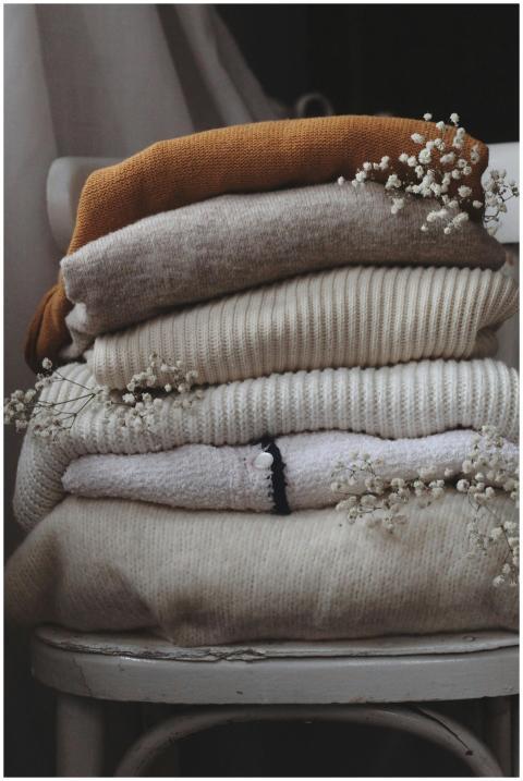 Aesthetic stack of beige and brown woolen sweaters