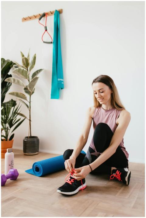 Young woman tying shoelaces in a home gym setting