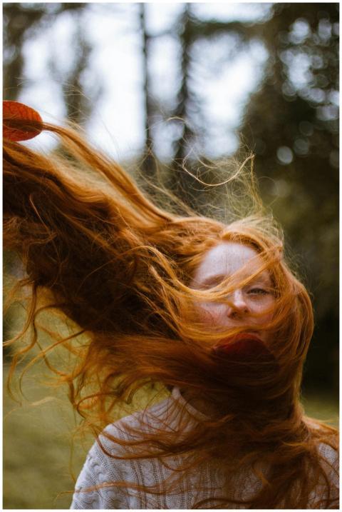 Vibrant portrait of a woman with red hair blowing