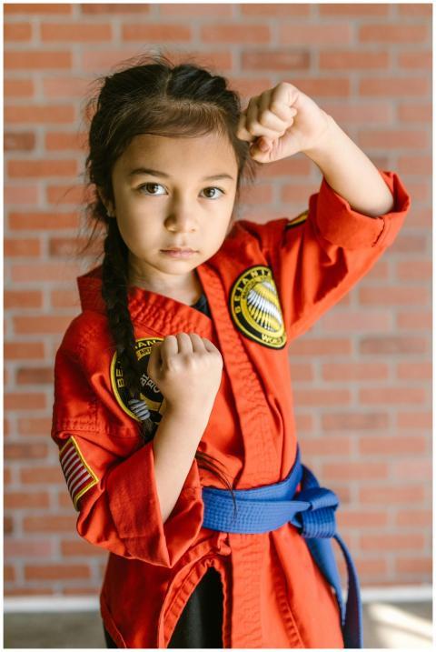 A young girl in martial arts uniform posing confid