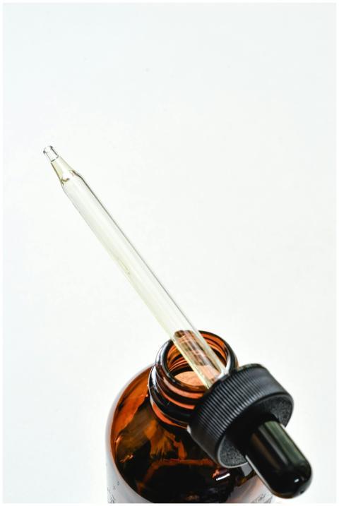 Close-up of a glass dropper in an amber bottle on