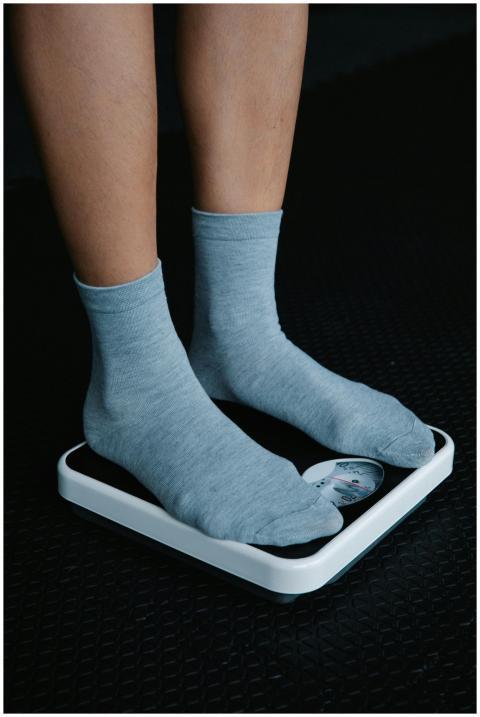 Close-up of feet in gray socks on a weighing scale