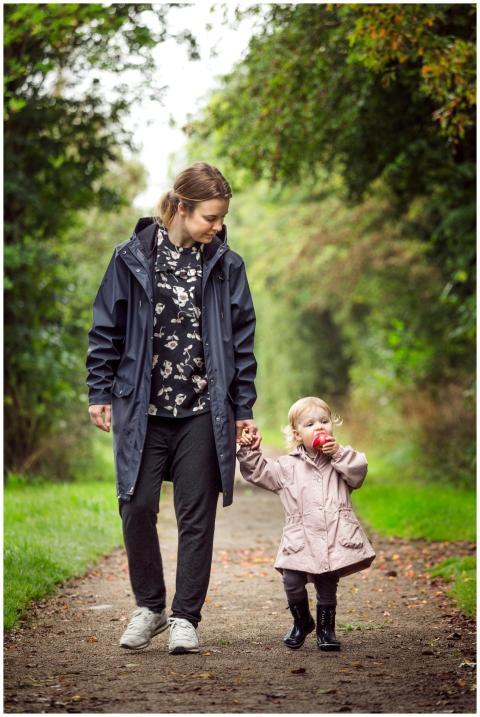 A mother and daughter walking on a forest pathway