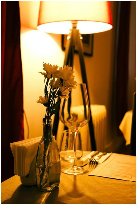 Warm and intimate table setup with flowers, wine g