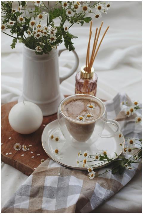 Warm chamomile latte with floral decor and diffuse