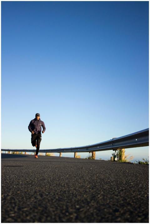 An athletic man jogging on an open road with a cle