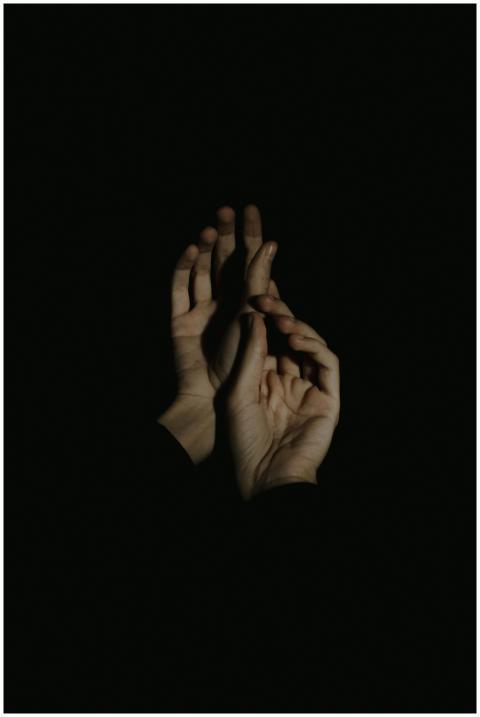 Artistic portrayal of hands in a minimalist dark s