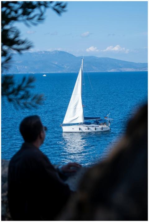 A picturesque sailboat glides on calm blue waters