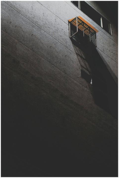 Gritty urban night scene showing a shadowy buildin