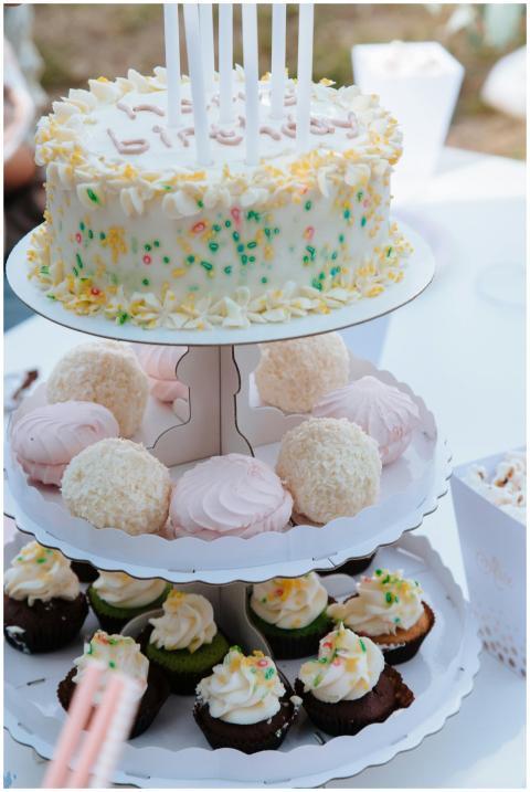 Festive display of birthday cake and cupcakes with
