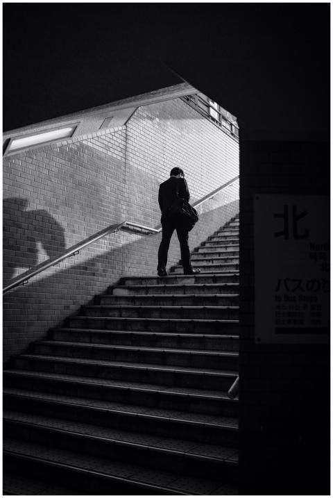 Black and white photograph of a man walking up a s