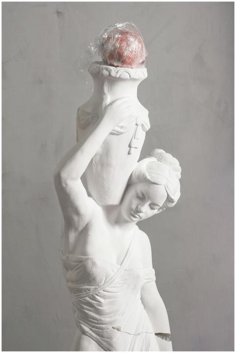 A classic white statue holding a modern element, c