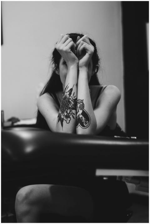 An artistic black and white portrait of a tattooed